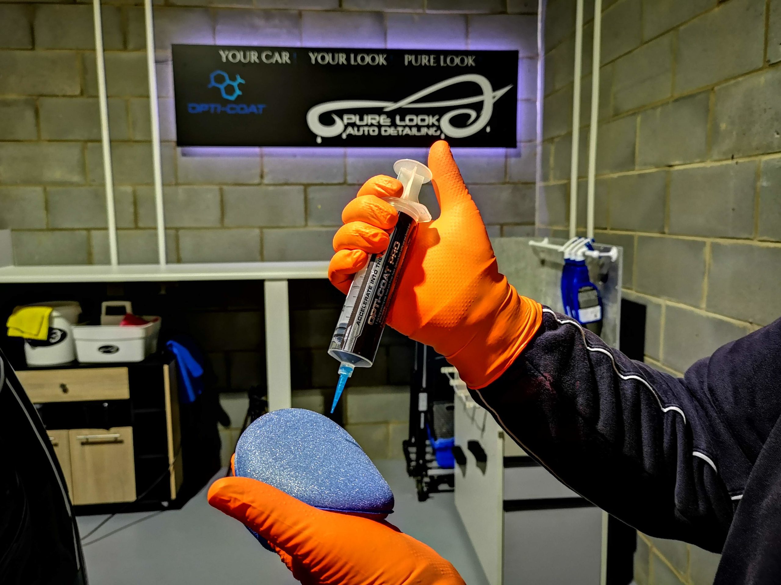person holding car ceramic coating paint protection while installing on the car