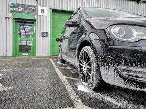 front of Pure Look Auto Detailing building with snow foamed car on the front