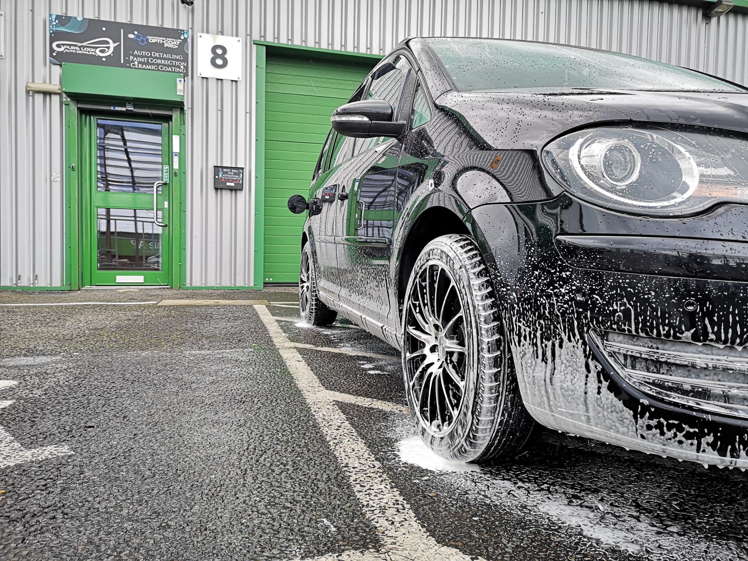 front of Pure Look Auto Detailing building with snow foamed car on the front